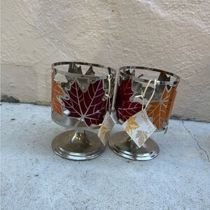 New! Set of two metal candle holders with autumn leaf design.